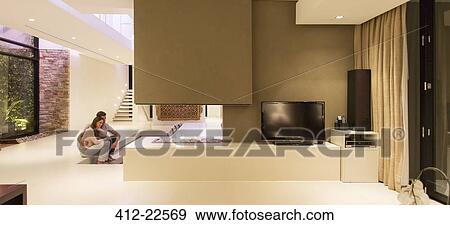 Stock Photo - Couple sitting in front of fireplace in modern living room. Fotosearch