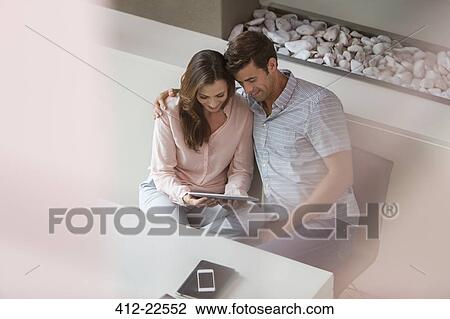 Couple using tablet pc in dining room View Large Photo Image Stock Image - Couple using tablet pc in dining room. Fotosearch