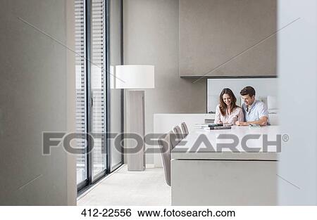 Couple using tablet pc in dining room View Large Photo Image Stock Photograph - Couple using tablet pc in dining room. Fotosearch