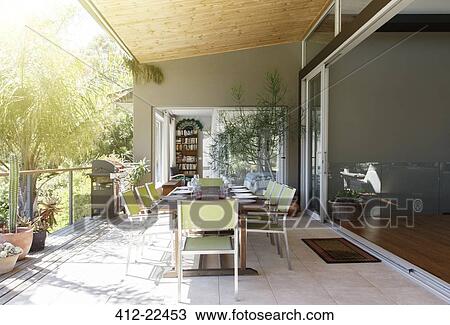 Stock Image - Dinning table and chairs in sunny patio. Fotosearch