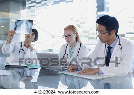 Doctors using laptop and watching patient's x-ray View Large Photo Image Picture - Doctors using laptop and watching patient's x-ray. Fotosearch