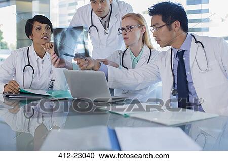 Doctors using laptop and watching patient's x-ray View Large Photo Image Stock Image - Doctors using laptop and watching patient's x-ray. Fotosearch