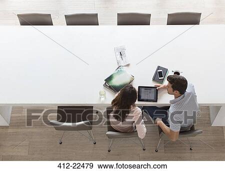 Elevated view of couple using tablet pc in dining room View Large Photo Image Stock Photo - Elevated view of couple using tablet pc in dining room. Fotosearch