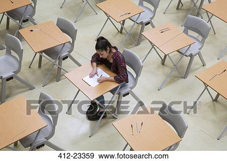 Elevated view of lone female student writing their GCSE exam in classroom View Large Photo Image Stock Photo - Elevated view of lone female student writing their GCSE exam in classroom. Fotosearch