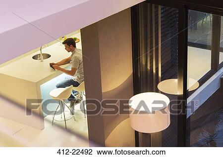 Elevated view of man using tablet pc in kitchen at night View Large Photo Image Stock Image - Elevated view of man using tablet pc in kitchen at night. Fotosearch