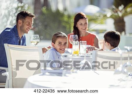 Family with two children having dinner in resort outdoors View Large Photo Image Stock Photography - Family with two children having dinner in resort outdoors. Fotosearch