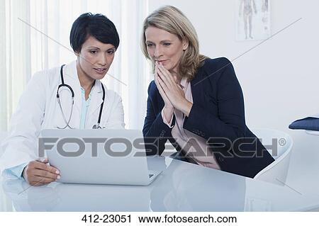 Female doctor and patient using laptop in hospital office View Large Photo Image Stock Image - Female doctor and patient using laptop in hospital office. Fotosearch