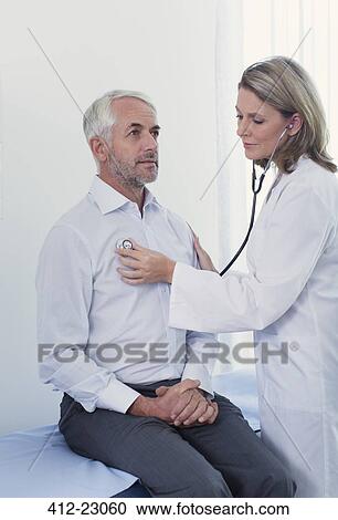 Female doctor examining her patient with stethoscope in office View Large Photo Image Stock Image - Female doctor examining her patient with stethoscope in office. Fotosearch