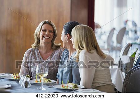 Female friends enjoying meal in restaurant View Large Photo Image Stock Image - Female friends enjoying meal in restaurant. Fotosearch