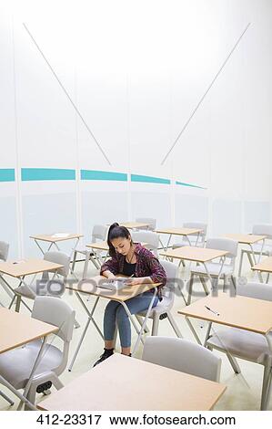 Stock Photo - Female student sitting alone in classroom during GCSE exam. Fotosearch
