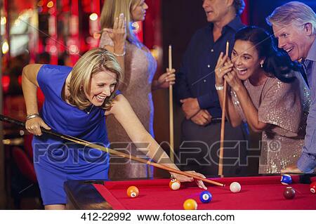 Friends playing pool in nightclub View Large Photo Image Stock Image - Friends playing pool in nightclub. Fotosearch