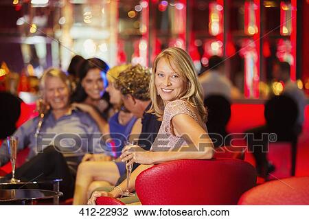 Stock Image - Group of friends having fun in bar. Fotosearch