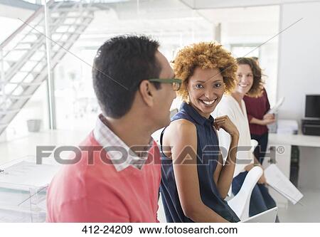 Stock Photo - Group of smiling business people having meeting in office. Fotosearch