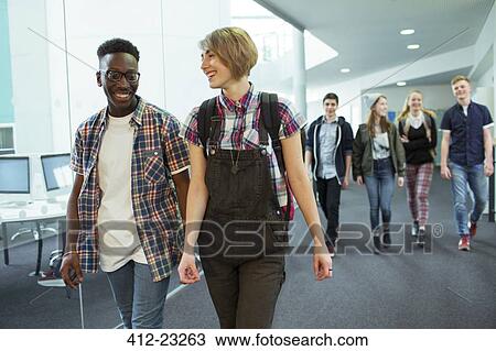 Stock Image - Group of students walking in corridor and smiling. Fotosearch