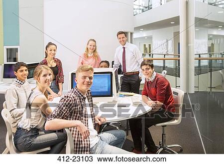 Group portrait of teenage students with their teacher at table View Large Photo Image Stock Image - Group portrait of teenage students with their teacher at table. Fotosearch