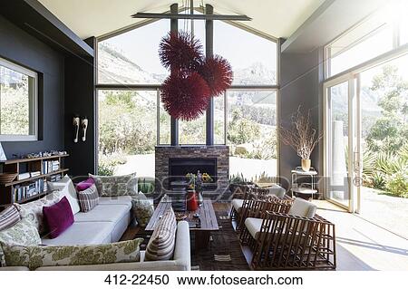 Stock Image - Living room with fireplace and modern chandelier. Fotosearch