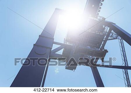 Low angle view of cargo crane against blue sky View Large Photo Image Picture - Low angle view of cargo crane against blue sky. Fotosearch