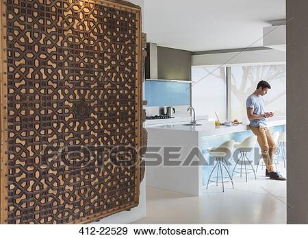 Man leaning against kitchen counter and texting View Large Photo Image Stock Photo - Man leaning against kitchen counter and texting. Fotosearch