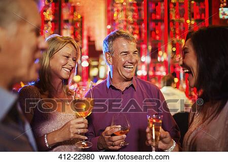 Mature men and women enjoying drinks in nightclub View Large Photo Image Stock Image - Mature men and women enjoying drinks in nightclub. Fotosearch