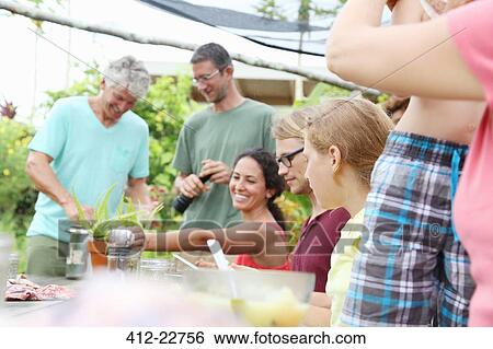Men and women at table in garden View Large Photo Image Stock Photograph - Men and women at table in garden. Fotosearch