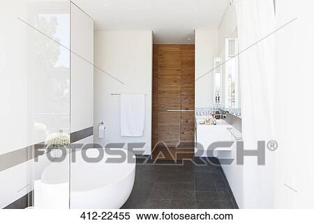 Modern bathroom interior with large bathtub and wooden door View Large Photo Image Stock Photography - Modern bathroom interior with large bathtub and wooden door. Fotosearch