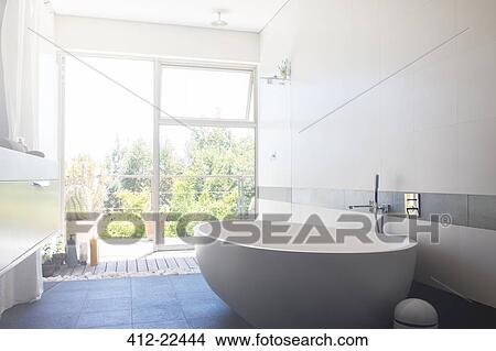 Modern bathroom with large white bathtub and patio door View Large Photo Image Picture - Modern bathroom with large white bathtub and patio door. Fotosearch