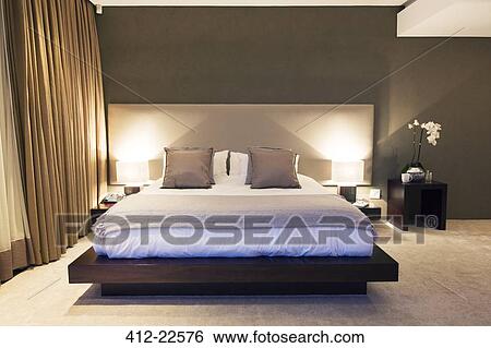Modern bedroom with double bed illuminated at night View Large Photo Image Stock Photograph - Modern bedroom with double bed illuminated at night. Fotosearch