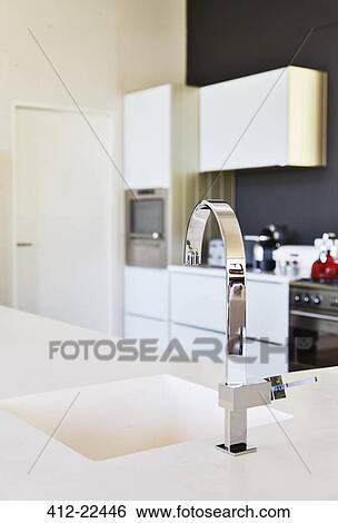 Modern stainless steel faucet and white kitchen sink in clean kitchen View Large Photo Image Stock Photograph - Modern stainless steel faucet and white kitchen sink in clean kitchen. Fotosearch