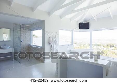 Modern white bathroom interior with large bathtub and shower area View Large Photo Image Stock Photo - Modern white bathroom interior with large bathtub and shower area. Fotosearch