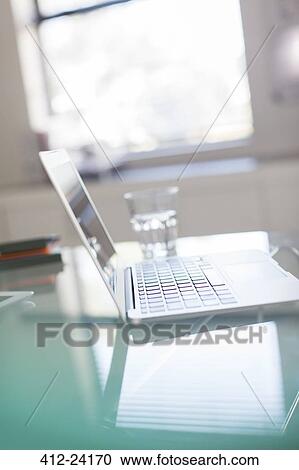 Open laptop and glass of water on glass desk in office View Large Photo Image Stock Image - Open laptop and glass of water on glass desk in office. Fotosearch