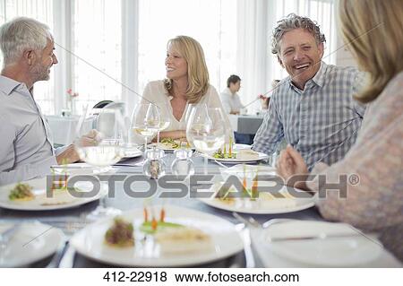 Stock Photo - People enjoying fancy meal in restaurant. Fotosearch
