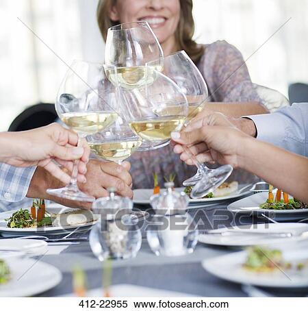 People toasting with white wine in restaurant View Large Photo Image Stock Photography - People toasting with white wine in restaurant. Fotosearch