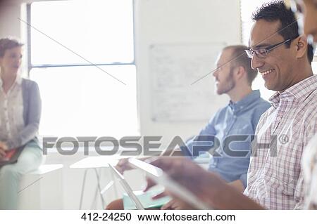 People working on tablets and laptops in office View Large Photo Image Stock Image - People working on tablets and laptops in office. Fotosearch