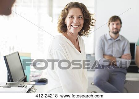 Portrait of businesswoman in office, colleague in background View Large Photo Image Stock Photo - Portrait of businesswoman in office, colleague in background. Fotosearch