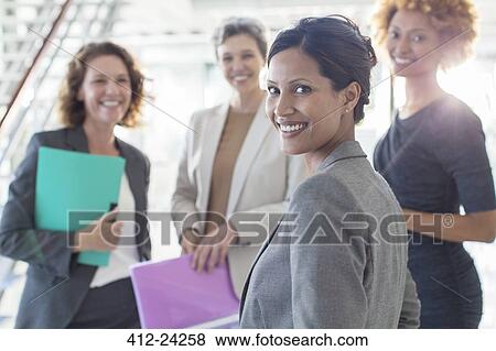 Portrait of four smiling businesswomen in office View Large Photo Image Stock Photo - Portrait of four smiling businesswomen in office. Fotosearch