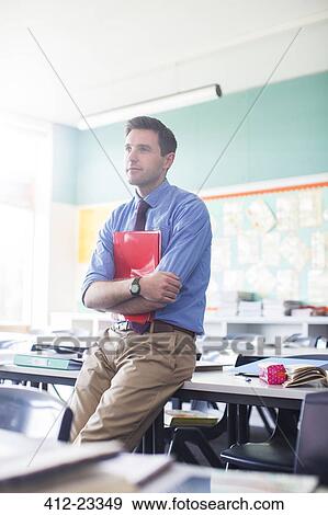 Portrait of male teacher leaning at desk in classroom View Large Photo Image Stock Photo - Portrait of male teacher leaning at desk in classroom. Fotosearch