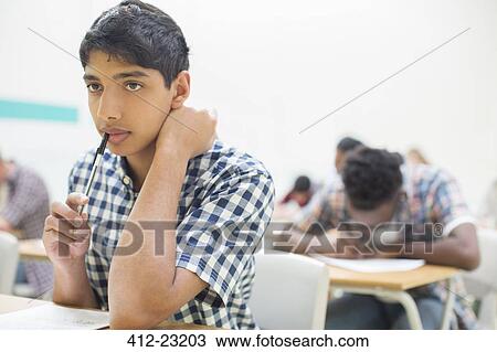 Stock Image - Portrait of pensive student during his GCSE examination. Fotosearch