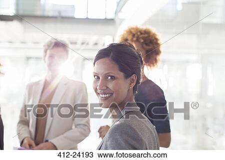 Portrait of smiling businesswoman with colleagues in background View Large Photo Image Stock Image - Portrait of smiling businesswoman with colleagues in background. Fotosearch