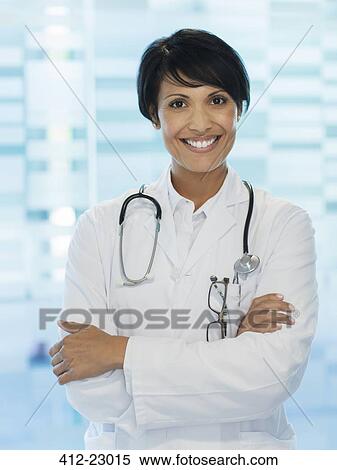 Portrait of smiling female doctor standing with arms crossed View Large Photo Image Stock Photography - Portrait of smiling female doctor standing with arms crossed. Fotosearch