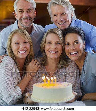 Portrait of smiling mature men and women with birthday cake View Large Photo Image Stock Image - Portrait of smiling mature men and women with birthday cake. Fotosearch