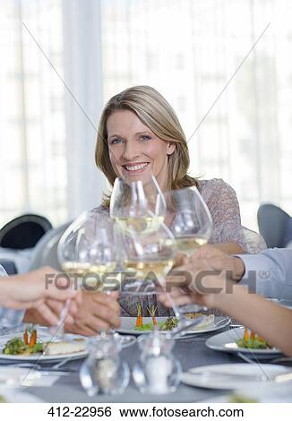 Portrait of smiling mature woman toasting with white wine in restaurant View Large Photo Image Stock Photograph - Portrait of smiling mature woman toasting with white wine in restaurant. Fotosearch