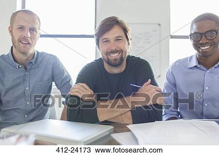 Stock Image - Portrait of three smiling businessmen in office. Fotosearch