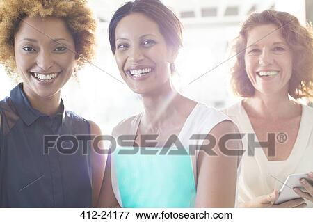Portrait of three smiling businesswomen in office View Large Photo Image Stock Photo - Portrait of three smiling businesswomen in office. Fotosearch
