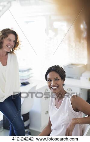 Portrait of two smiling women in office View Large Photo Image Stock Image - Portrait of two smiling women in office. Fotosearch