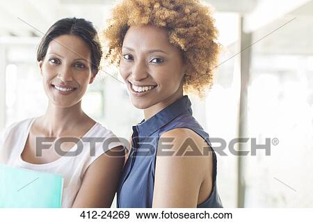 Stock Photo - Portrait of two smiling women in office. Fotosearch
