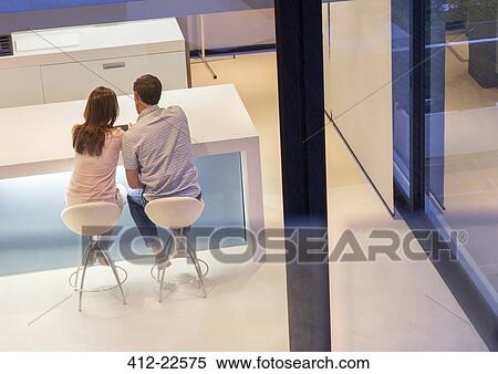 Rear view of couple using tablet pc in dining room View Large Photo Image Stock Photography - Rear view of couple using tablet pc in dining room. Fotosearch
