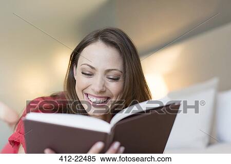 Smiling woman reading book in bedroom View Large Photo Image Stock Photography - Smiling woman reading book in bedroom. Fotosearch