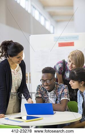Students and teacher working with laptop View Large Photo Image Stock Photo - Students and teacher working with laptop. Fotosearch