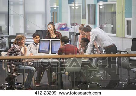 Stock Photo - Students during IT lesson in modern classroom with glass walls. Fotosearch