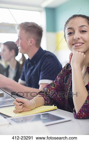 Stock Image - Students in classroom posing during lesson. Fotosearch